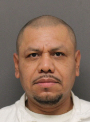 Booking-style photograph identified as Jorge Menendez.